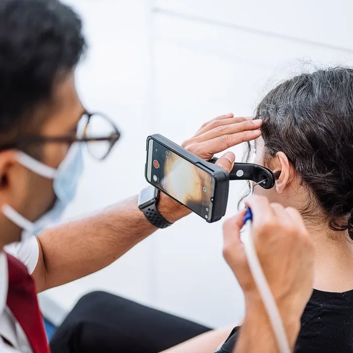 Patient having their earwax removed using microsuction